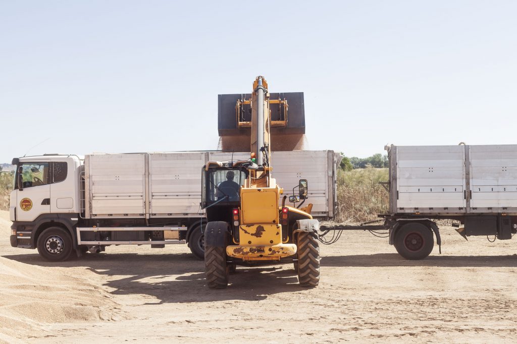 Bulldozer filling an articulated lorry with wheat grain. Harvest 2021. © Juan San Sebastián.